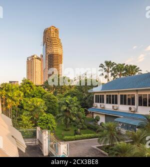 Urbane Szene. Verlassene Wolkenkratzer mit Grün beleuchtet von Golden Light in Bangkok, Thailand. Stockfoto