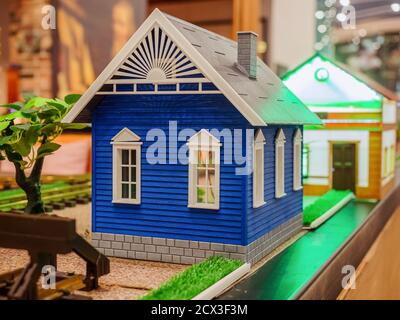 Blaues Miniaturhaus mit grauem Dach und weißen Fenstern Stockfoto