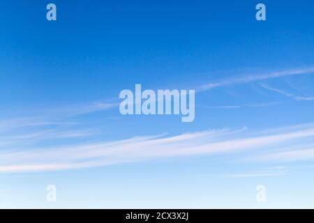 Blauer Himmel mit Streifen von Zirruswolken am Tag, natürliche Hintergrund Foto Textur Stockfoto