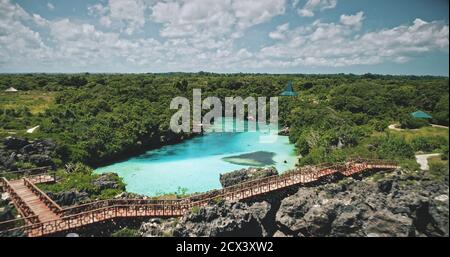 Grüne Klippe Ozeanküste mit limpid See an tropischen Pflanzen und Bäumen in Luftaufnahme. Atemberaubende Naturlandschaft am Weekuri See, Sumba Insel, Indonesien, Asien. Grüne felsige Küste am Meer bei Drohne erschossen Stockfoto