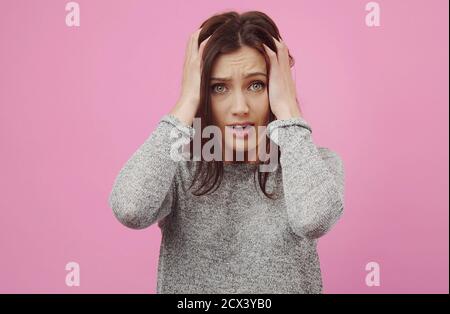 Schockierte junge Frau, die den Kopf berührt Stockfoto