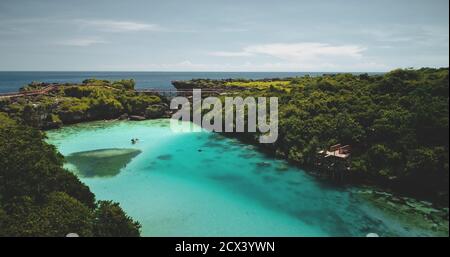 Türkisfarbener See mit Blick auf ruhende Menschen. Touristen schwimmen in azurblauen kristallklaren Lagune bewundern grüne tropische Bäume Landschaft. Filmischer Sommerurlaub am Salt Water Weekuri loch in Drohnenaufnahme Stockfoto