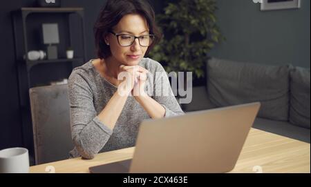 Frau, die sich etwas auf dem Laptop ansieht Stockfoto