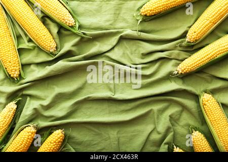 Frischer Mais auf Maiskolben auf grünem Hintergrund. Draufsicht mit Kopierbereich. Rahmen. Stockfoto