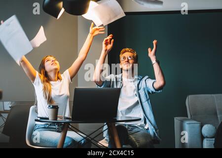 Kollegen feiern, indem sie ihre Papiere Dokumente fliegen in der Luft Stockfoto