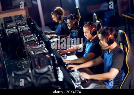 Konzentriert sich auf das Spiel. Team von professionellen Cyber-Sport-Gamer tragen Kopfhörer Teilnahme an eSport-Turnier, während im Gaming-Club oder Internet-Café sitzen Stockfoto