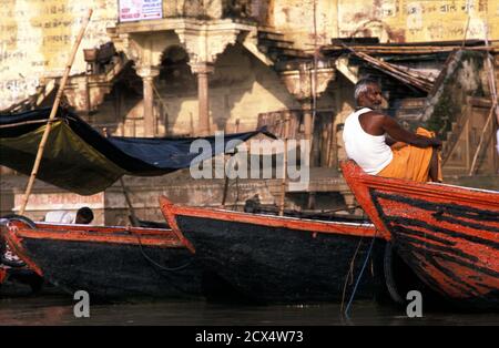 Bootsmann auf seinem Schiff. Neben den Ghats am Ganges. Varanasi Indien Stockfoto