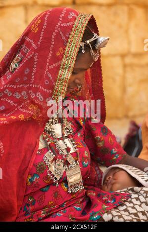Portarit einer Rajasthani Frau in unverwechselbaren Rajasthani Kleid mit Baby, Jaisalmer, Indien Stockfoto