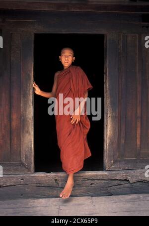 Ein Novizmönch tritt aus dem Nachmittagsgebet hervor. Bagaya Kyaung, Ava. In der Nähe von Mandalay. Jeder Mönche Robe hat drei Teile, das äußere Gewand genannt Tricivara die unter Gewand genannt die uttarasnga und der Mantel genannt die samghati Stockfoto