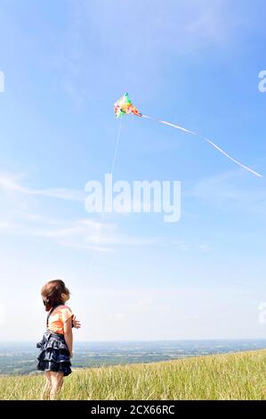 Mädchen fliegen einen Drachen in der englischen Landschaft. Stockfoto