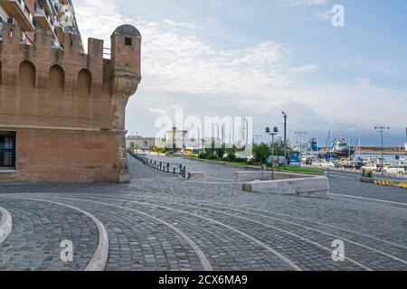 Civitavecchia, Italien - 30. Oktober 2019: Blick auf die Straße Calata della Rocca mit seinem gepflasterten Zugang, Meer vor Steinmauer, Marina und Fort Michelan Stockfoto