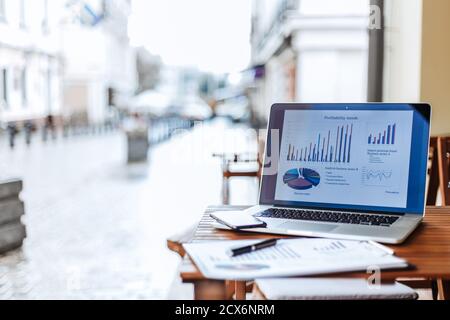 Nahaufnahme. Laptop und Finanzkarte auf einem Tisch in einem Straßencafe . Stockfoto