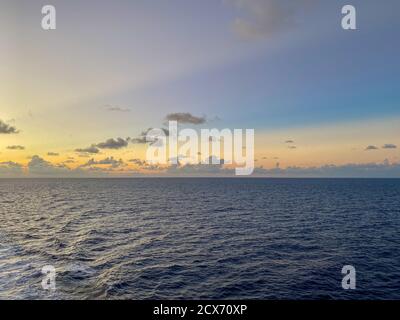 Ein wunderschöner rosa, blau und orange Sonnenuntergang über dem karibischen Meer an einem verschwommenen Abend. Stockfoto