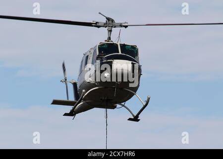 G-UHGB, eine Bell 205A-1, die von Heli-Lift Services betrieben wird, führt Pylonen-Abbauarbeiten in den Hügeln von Renfrewshire/Inverclyde in Schottland durch. Stockfoto