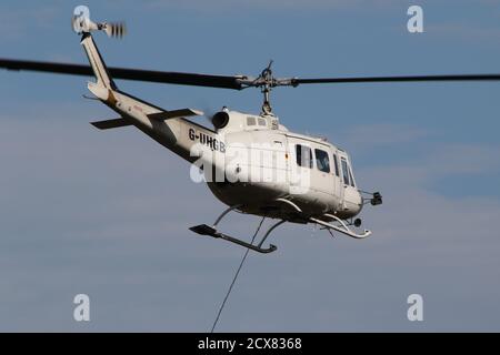 G-UHGB, eine Bell 205A-1, die von Heli-Lift Services betrieben wird, führt Pylonen-Abbauarbeiten in den Hügeln von Renfrewshire/Inverclyde in Schottland durch. Stockfoto