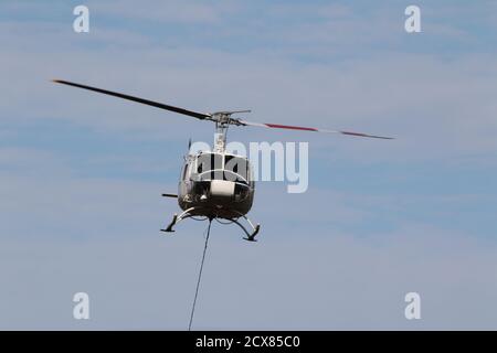 G-UHGB, eine Bell 205A-1, die von Heli-Lift Services betrieben wird, führt Pylonen-Abbauarbeiten in den Hügeln von Renfrewshire/Inverclyde in Schottland durch. Stockfoto