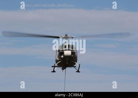 G-UHGB, eine Bell 205A-1, die von Heli-Lift Services betrieben wird, führt Pylonen-Abbauarbeiten in den Hügeln von Renfrewshire/Inverclyde in Schottland durch. Stockfoto