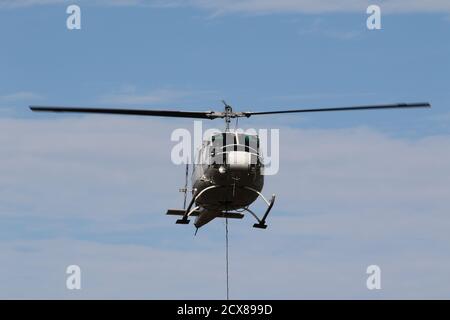 G-UHGB, eine Bell 205A-1, die von Heli-Lift Services betrieben wird, führt Pylonen-Abbauarbeiten in den Hügeln von Renfrewshire/Inverclyde in Schottland durch. Stockfoto