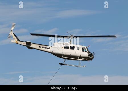 G-UHGB, eine Bell 205A-1, die von Heli-Lift Services betrieben wird, führt Pylonen-Abbauarbeiten in den Hügeln von Renfrewshire/Inverclyde in Schottland durch. Stockfoto