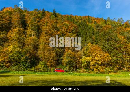 Kleines rotes Auto durch schöne Herbstlandschaft bei Graz, Steiermark Region, Österreich Stockfoto