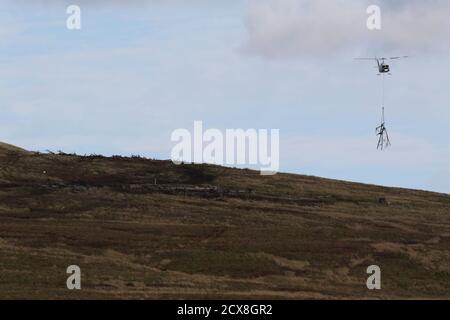 G-UHGB, eine Bell 205A-1, die von Heli-Lift Services betrieben wird, führt Pylonen-Abbauarbeiten in den Hügeln von Renfrewshire/Inverclyde in Schottland durch. Stockfoto