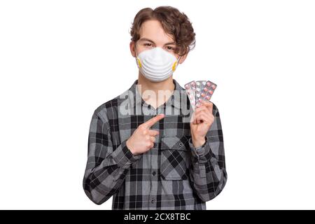 Coronavirus-Quarantäne. COVID-19 - Selbstisolierung zu Hause. Kind trägt medizinische Schutzmaske, isoliert auf weiß. Teen junge hält Pillen. Stockfoto