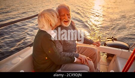 Romantischer Abend auf dem Boot. Porträt eines glücklichen älteren Paares, das die Hände hält, umarmt und küsst Stockfoto