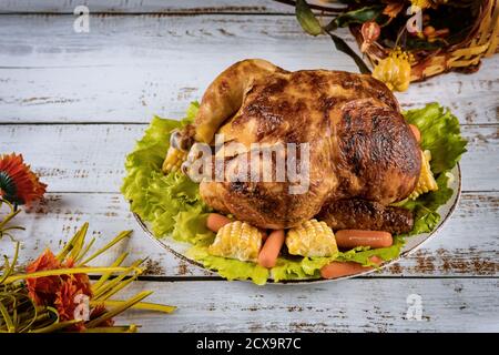 Thanksgiving Day gebratenes Hähnchen Thanksgiving-Tisch mit dekorierten hellen Herbstblättern auf dem Tisch. Stockfoto