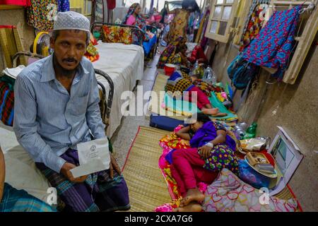 Das Dhaka Medical College Hospital kämpft darum, den Ansturm von Patienten fünfmal über seine Kapazität hinaus zu bewältigen. Als Ergebnis, Patienten und ihre Teilnehmer Stockfoto