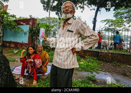 Eine Begleitperson hält einen Kochsalzlösung IV Tropfen außerhalb des Dhaka Medical College Hospital, als sie auf die Aufnahme wartet. Dhaka, Bangladesch Stockfoto