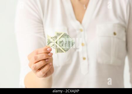 Frau mit Origami-Fisch aus Dollar-Banknote, Nahaufnahme Stockfoto