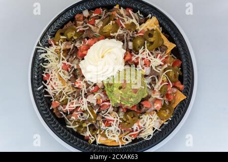 Blick von oben auf eine herzhafte Mahlzeit von Carne Asada Nachos verleitet die Geschmacksnerven, die gesamte Mahlzeit zu essen. Stockfoto