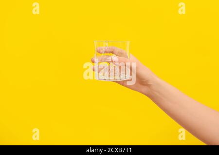 Hand mit leerem Glas auf farbigem Hintergrund Stockfoto