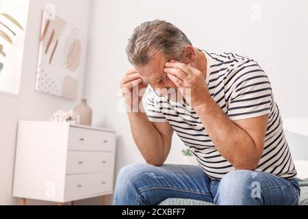 Gestresster reifer Mann zu Hause Stockfoto