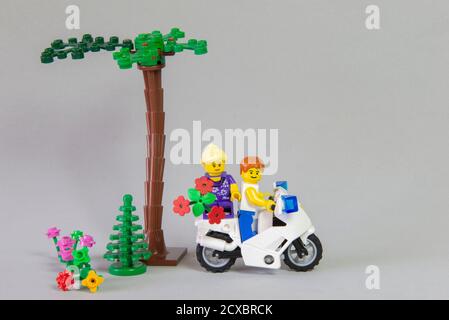 Florianopolis, Brasilien. 19. September 2020: Minifigur eines Motorradfahrers mit seiner Freundin auf dem Rumpf, der einen Blumenstrauß auf Weiß hält Stockfoto