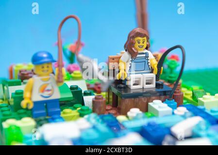 Florianopolis, Brasilien. 20. September 2020: Vorderansicht von Mini Figur glückliche Mutter und Sohn Angeln am Fluss. Kind fängt einen großen Fisch mit seiner fis Stockfoto