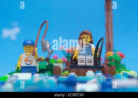 Florianopolis, Brasilien. 20. September 2020: Vorderansicht von Mini Figur glückliche Mutter und Sohn Angeln am Fluss. Kind fängt einen großen Fisch mit seiner fis Stockfoto