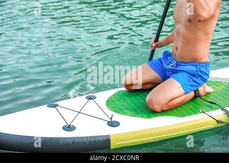 Junger Mann mit Paddle Board für sup Surfen im Fluss Stockfoto