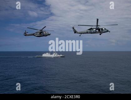 Ein US Navy MH-60S Seahawk Hubschrauber zugeordnet zu den "Ghost Riders" von Hubschrauber Sea Combat Squadron (HSC) 28, rechts, und ein italienischer NH 90 Hubschrauber ausführen einen Vorbeiflug der italienischen Marine Fregatte SEINE Federico Martinengo (F 596) Während einer Verfolgungsübung mit der Expeditionary Sea Base USS Hershel „Woody“ Williams (ESB 4) und dem Ghana Navy Snake-class Patrouillenschiff Ehwor (P37), nicht abgebildet, im Golf von Guinea, 28. September 2020. Hershel „Woody“ Williams ist auf seiner ersten Einsatz in der US-Naval Forces Europa-Afrika-Bereich der Verantwortung zur Unterstützung von maritimen Missionen und Sondereinsatz Stockfoto