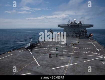 Ein US Navy MH-60S Seahawk Hubschrauber zugeordnet zu den "Ghost Riders" von Hubschrauber Sea Combat Squadron (HSC) 28, Front, Und ein italienischer NH 90 Hubschrauber landet auf der Expeditionary Sea Base Hershel „Woody“ Williams (ESB 4) während einer Verfolgungsübung mit der italienischen Marine Fregatte FEDERICO Martinengo (F 596) und dem Ghana Navy Snake-Klasse Patrouillenschiff Ehwor (P 37) im Golf von Guinea, 28. September 2020. Hershel „Woody“ Williams ist auf seiner ersten Einsatz in der US-Naval Forces Europa-Afrika Bereich der Verantwortung für die Unterstützung von maritimen Missionen und Sondereinsätze. (USA Marine Corps Foto Stockfoto