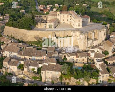 LUFTAUFNAHME. Mittelalterliche Burg auf einem felsigen Hügel, mit Blick auf das alte Dorf gebaut. Schloss Grignan, Drome, Auvergne-Rhône-Alpes, Frankreich. Stockfoto