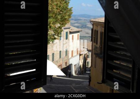 Offene Fensterläden mit Blick auf das Dorf Montalcino und die Toskanische Landschaft Stockfoto