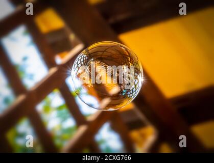 Eine große Seifenblase wird auf der Veranda gestartet. Stockfoto