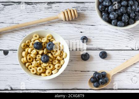 Honigringe mit Heidelbeeren in einer Schüssel auf dem Holzhintergrund. Speicherplatz kopieren. Draufsicht. Flach liegend. Horizontale Ausrichtung. Stockfoto