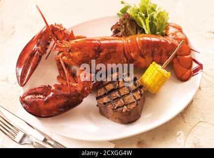 Gegrillter Hummer und Rindersteak auf dem Speiseteller Stockfoto