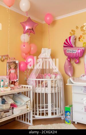 Das Bett des Mädchens in der Ecke des Zimmers ist mit Luftballons dekoriert. Stockfoto