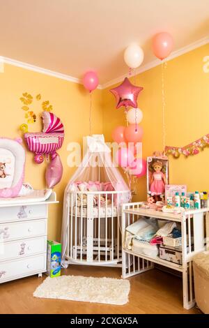 Das Bett des Mädchens in der Ecke des Zimmers ist mit Luftballons dekoriert. Stockfoto