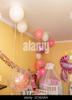 Das Bett des Mädchens in der Ecke des Zimmers ist mit Luftballons dekoriert. Stockfoto