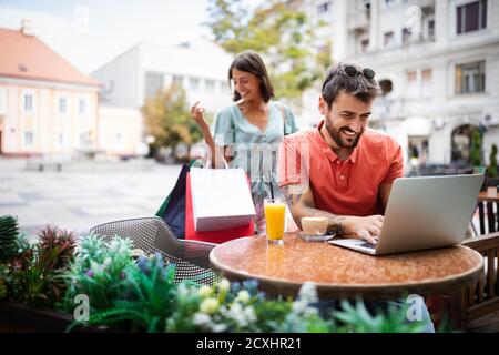 Schöne junge Frau überrascht ihren Freund in einem Straßencafé Stockfoto