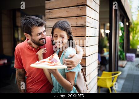 Glückliches Paar, das während der Reise Pizza isst Stockfoto